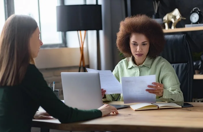 Serious concentrated recruitment manager reading resume hiring for job new employee