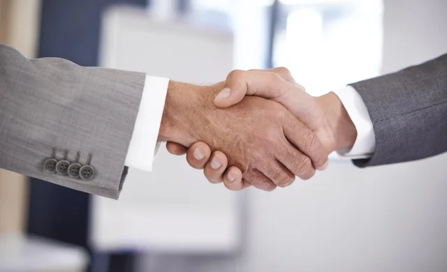 Close up of two hands shaking as if to seal a deal