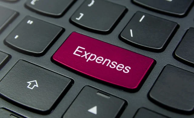 Close-up of a keyboard with an Expenses button in red.