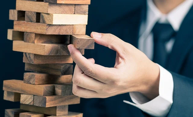 Close up of hadn pulling out a jenga block from a pile