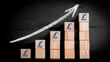 Wooden building blocks in piles getting higher with a pound sign and a graphic swoosh going up