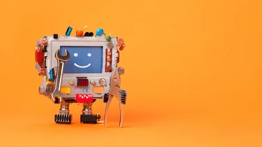 A smiling toy robot on orange background