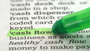 A green pen highlights the text "cash flow" on text defining what cashflow is.