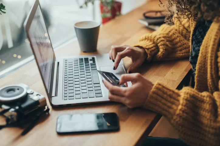 Person entering card details on laptop to take online payments securely