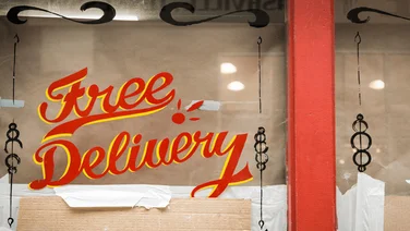 Graphic on a glass window saying "Free Delivery"