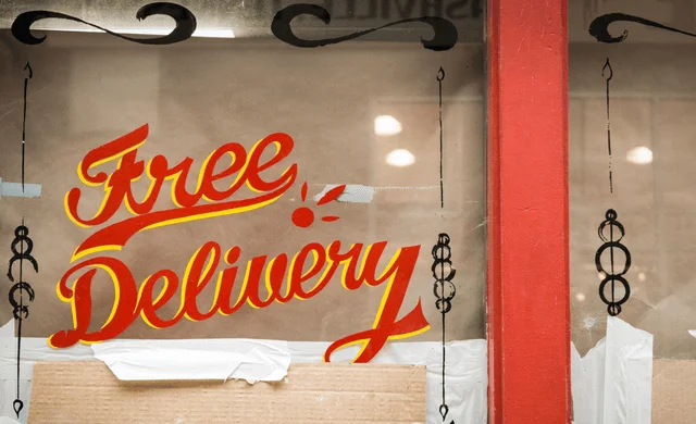 Graphic on a glass window saying "Free Delivery"