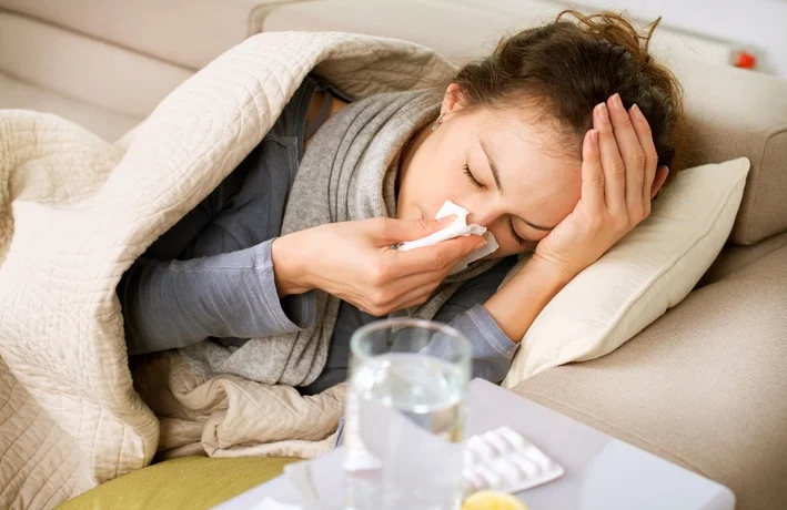 Unwell woman lying on a sofa