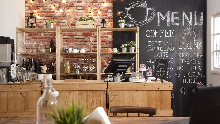 Wooden cafe counter with blackboard menu behind
