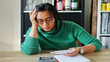 Business woman looking with concern at piece of paper