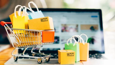 mini shopping trolley full of bags on a computer keyboard