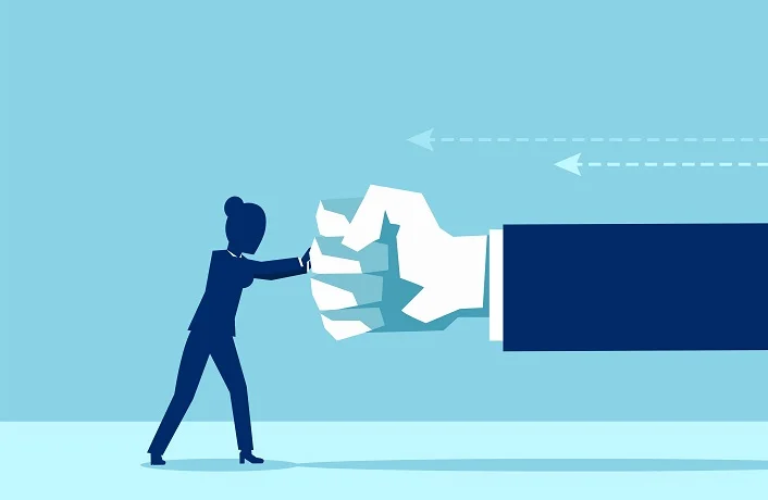Vector of a woman fighting back a giant fist, protecting herself from work abuse