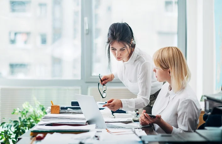 Colleagues working in office in front of computer