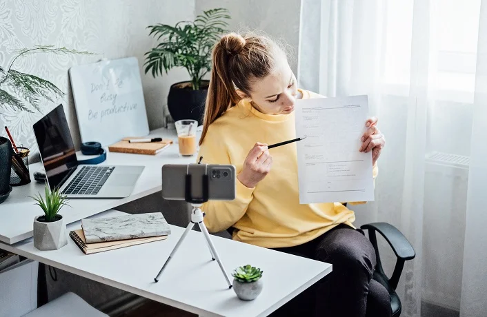 Passive Income, Side Hustle Ideas to Earn at Home. Young woman speaking in front of camera for vlog as blogger, recording video tutorial or training course. Earn extra money, money making.