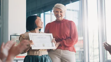 Applause, award and success with business woman in meeting for goal, thank you and winner. Celebration, praise and promotion with business people and certificate for support, achievement and branding.