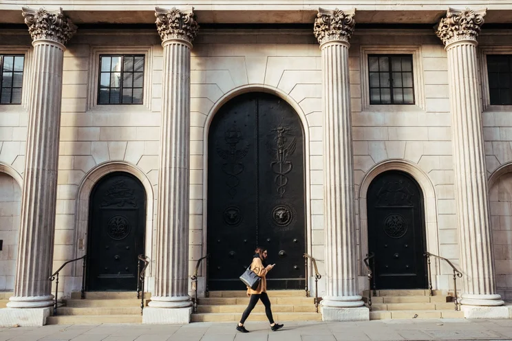 A woman walking past a bank