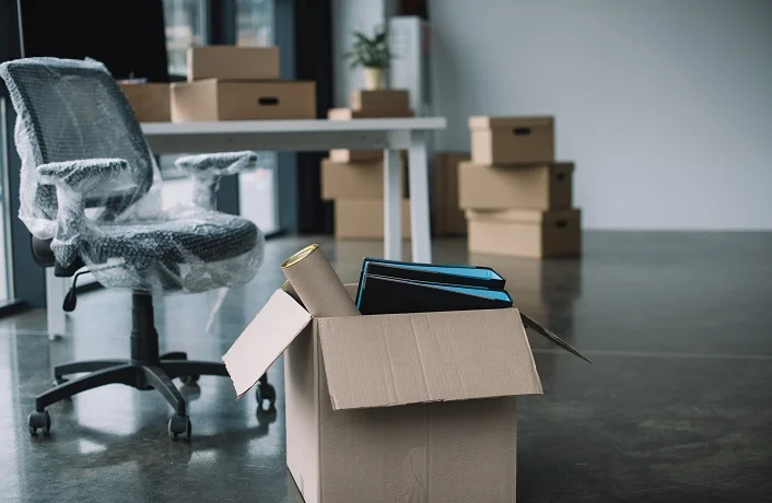 cardboard box with folders and office supplies in floor during r