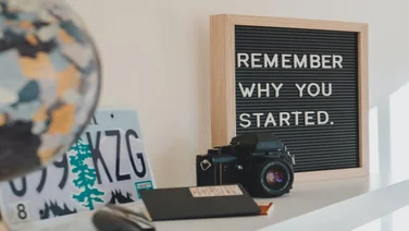 camera on a shelf next to a mission statement