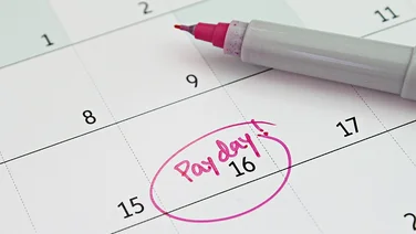 Close up of a calendar with pay day circled in pen.