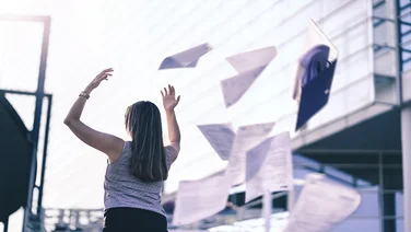 Business woman throwing work papers in the air. Stress from work