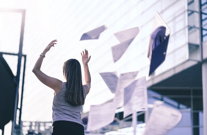 Business woman throwing work papers in the air. Stress from work