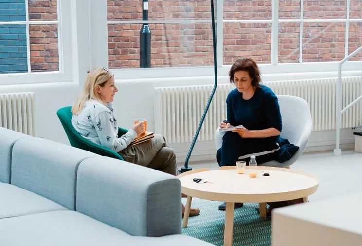 two businesswomen having a discussion in an office