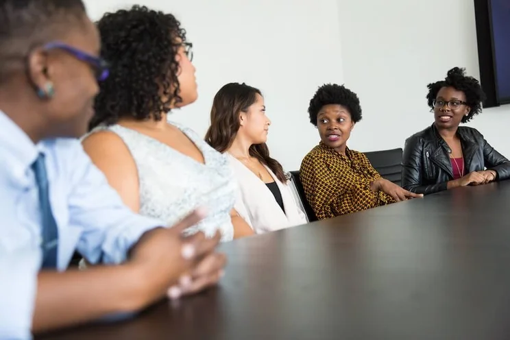 a group of businesswomen speaking at a table