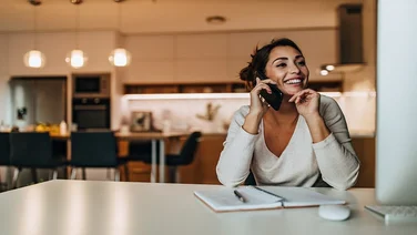 Smiling woman, dressed casually, having phone call.