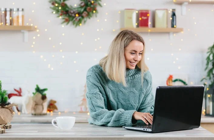 Business woman working at home on laptop during Christmas and New Year, happy and successful completes a big project