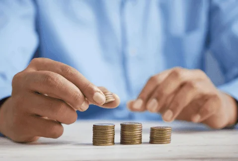 Person counting coins into piles
