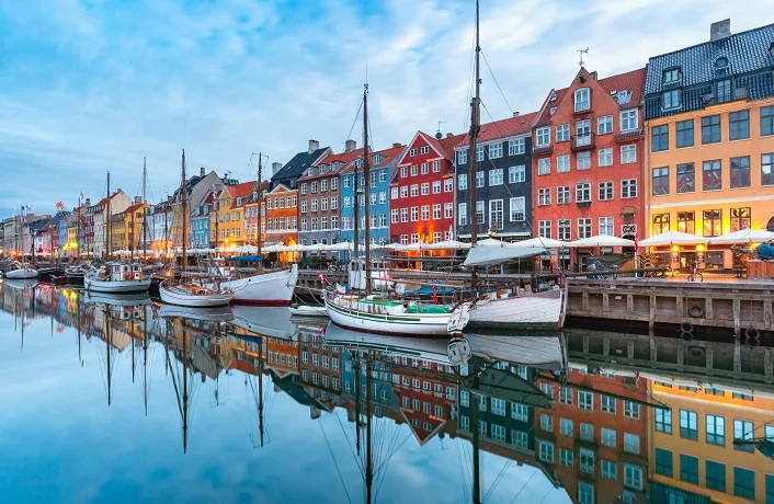 Nyhavn with colorful facades of old houses and old ships in the Old Town of Copenhagen, capital of Denmark.