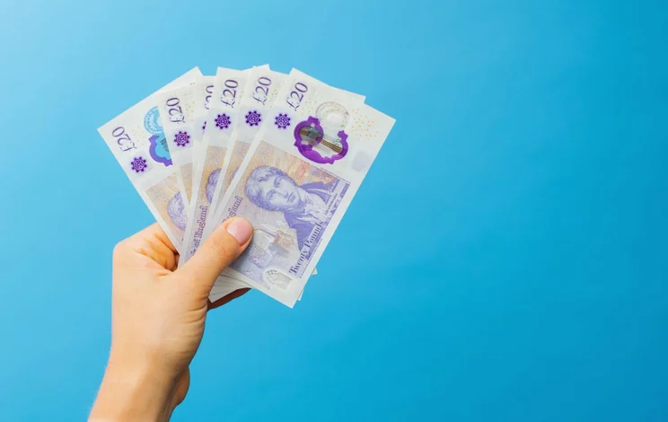 Person holding several &pound;20 notes