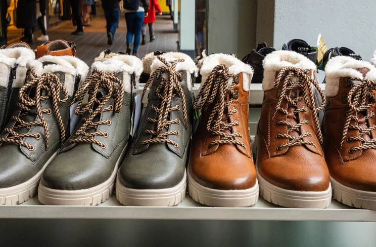a line up of identical looking black and brown boots