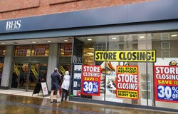 The front of a BHS store with closing down signs across the windows.