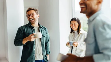 Group of colleagues sharing a coffee and laughing