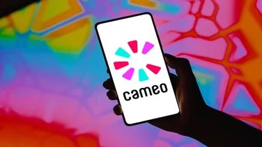 A hand holding up a smartphone device with the Cameo logo displayed on the screen.