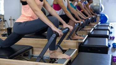 reformer pilates class goers doing exercise.