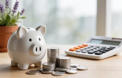 A piggy bank, coins and a calculator.
