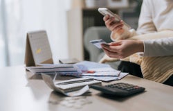 A person using a credit card to buy something on their phone.